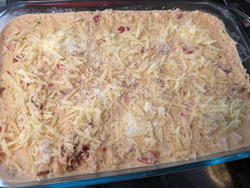 Creamy Keto Turkey Bacon and Tomato Casserole ready to bake in a casserole dish topped with cheese
