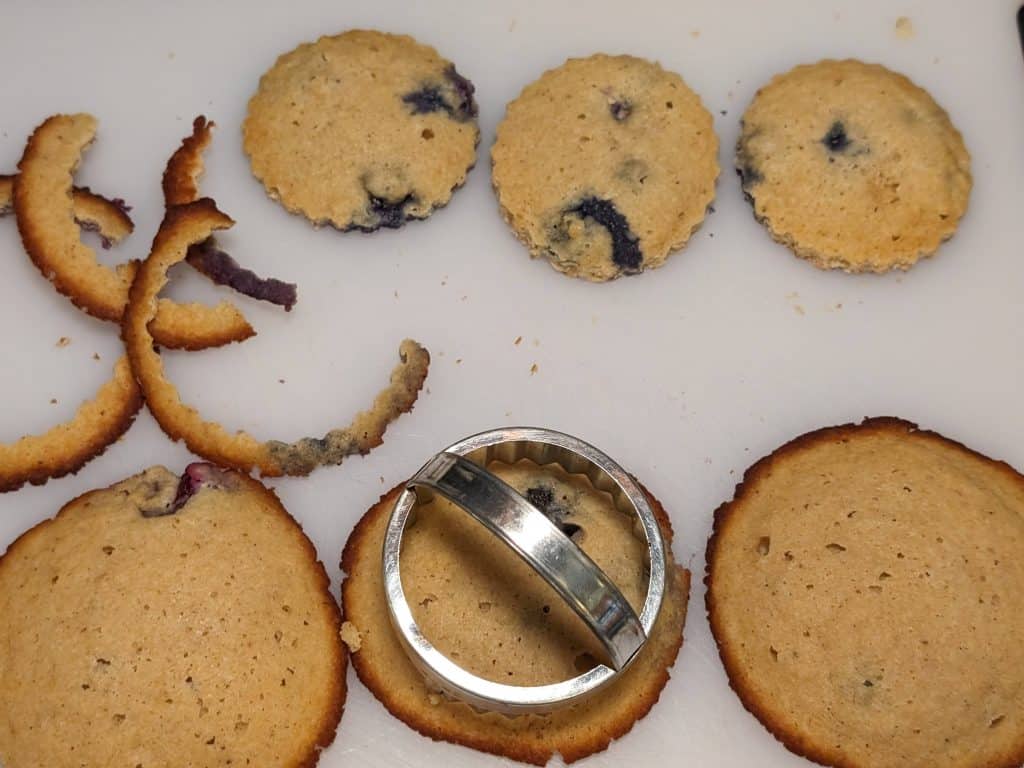 Cutting Keto Blueberry Spice Cookies with a 2.5-inch muffin cutter on a cutting board