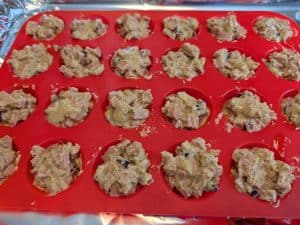 Chili Cheese Dog Puff batter in a silicone mini muffin pan ready to bake