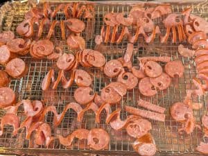 Spiralized smoked sausage laid out on a baking rack to roast