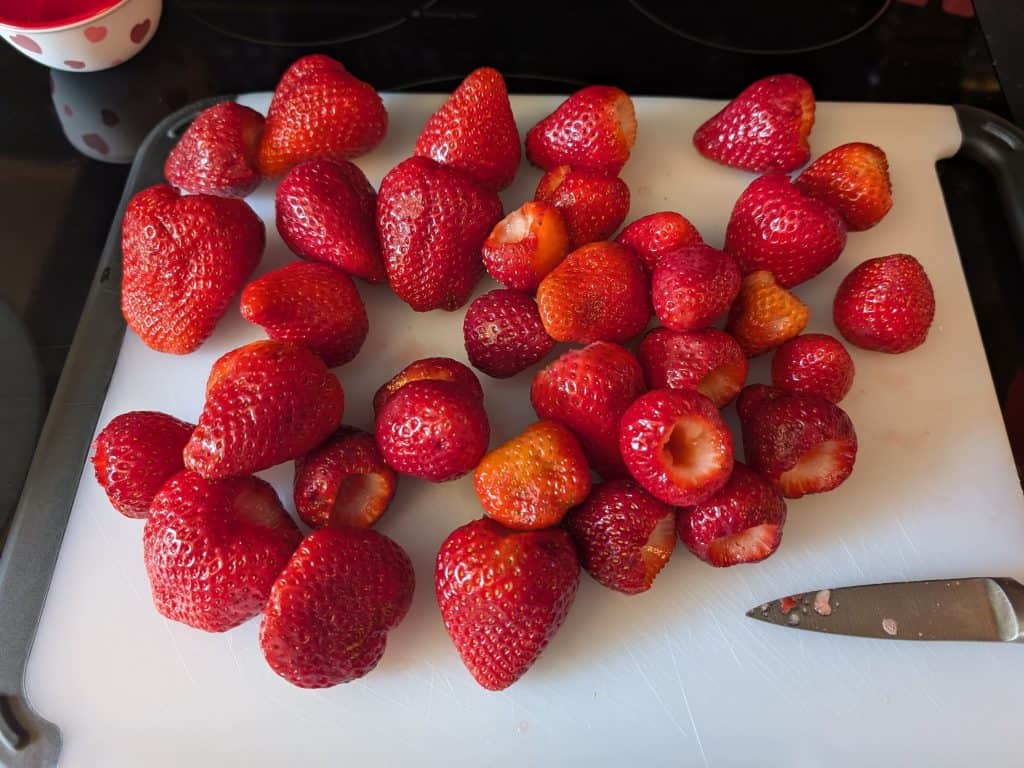 Hulled strawberries on a cutting board