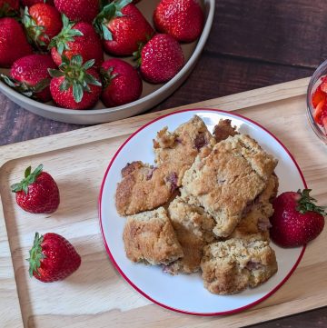 Strawberry Almond Flour Scones plated next to a bowl of strawberries