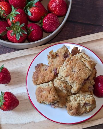 Strawberry Almond Flour Scones plated next to a bowl of strawberries