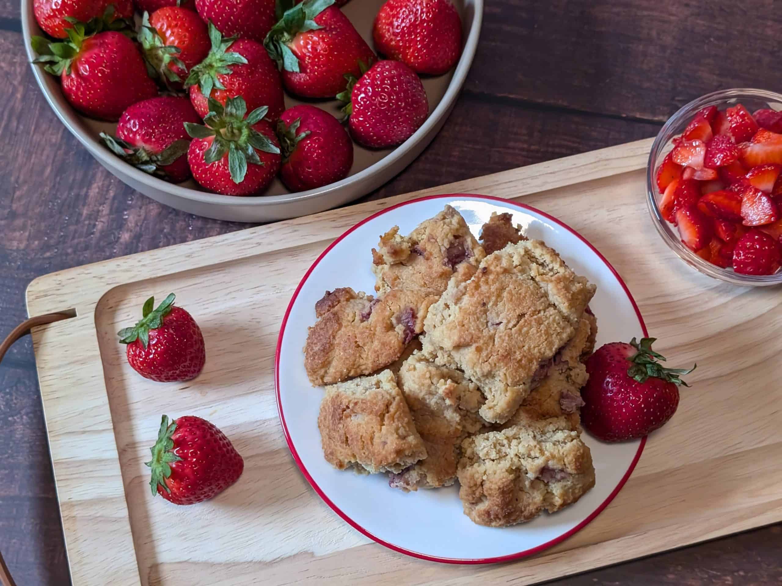 Strawberry Almond Flour Scones plated next to a bowl of strawberries