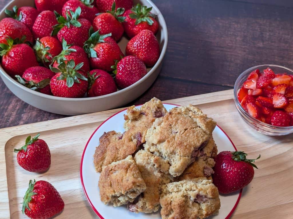 Strawberry Almond Flour Scones plated next to a bowl of strawberries