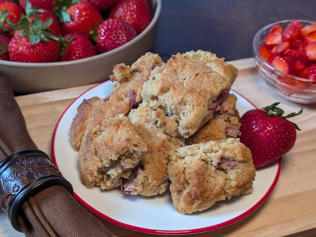 Close-up of Strawberry Almond Flour Scones plated next to a bowl of strawberries