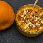 Spicy Pumpkin Pecan Dip in serving bowl next to a pumpkin