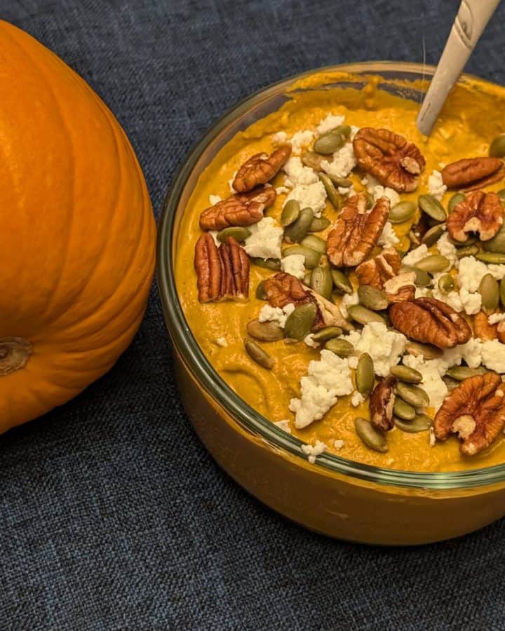 Spicy Pumpkin Pecan Dip in serving bowl next to a pumpkin