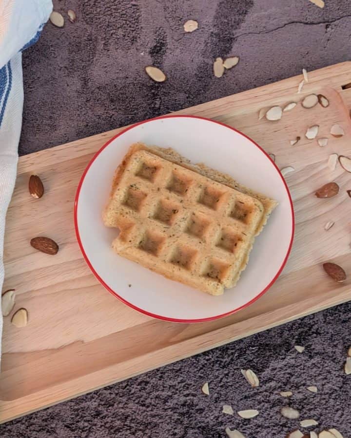 Savory Herbed Waffles plated with some scattered almond slices