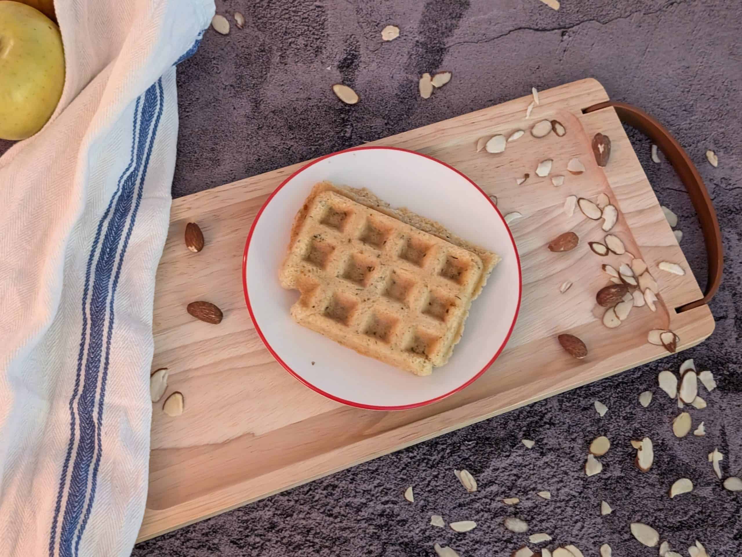 Savory Herbed Waffles plated with some scattered almond slices