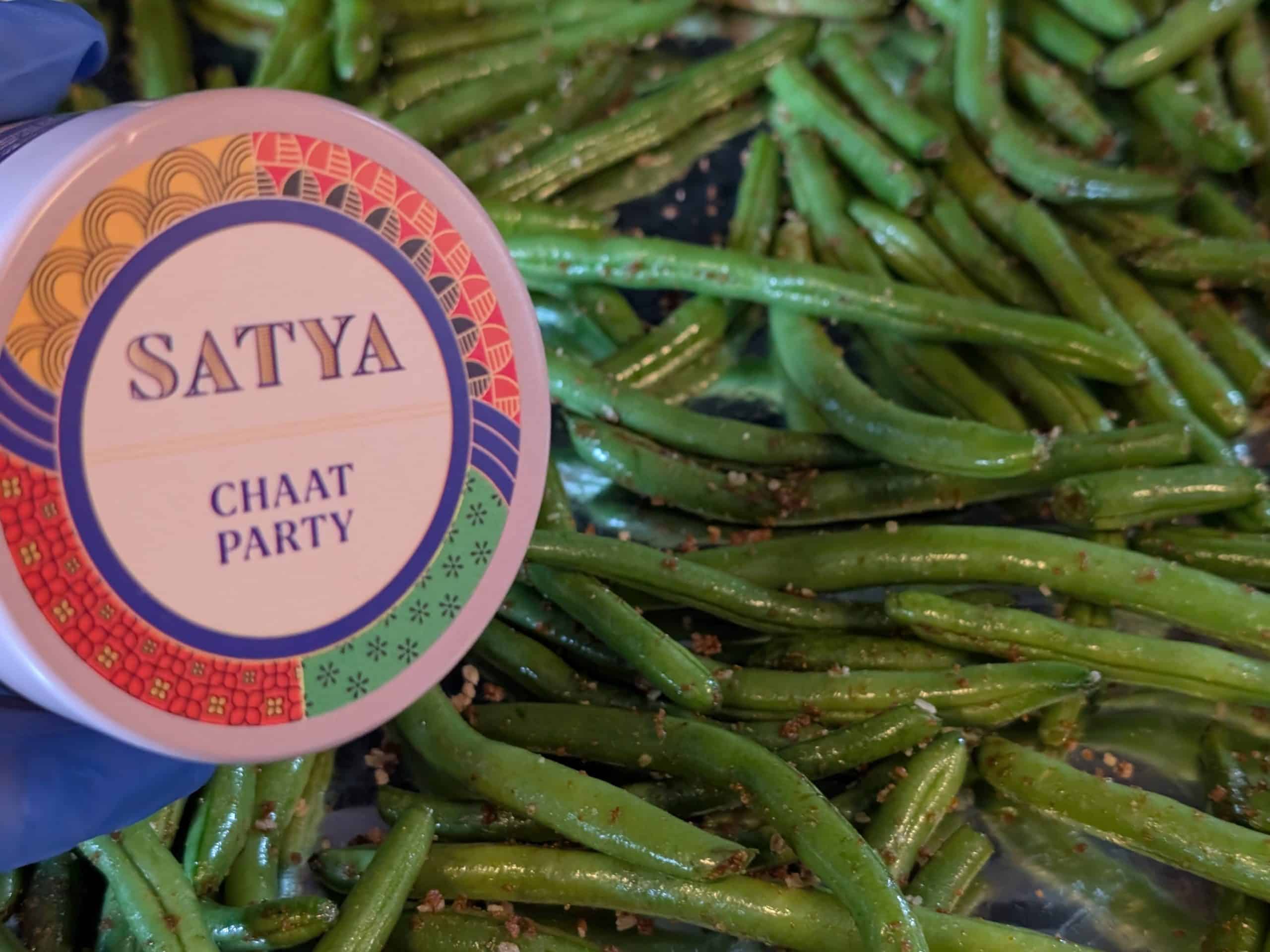 Raw green beans seasoned with Chaat Party Spice Blend on a sheet pan ready to roast