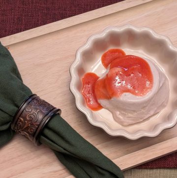 Strawberry Mango Sutra Panna Cotta in a serving dish topped with Strawberry Purée