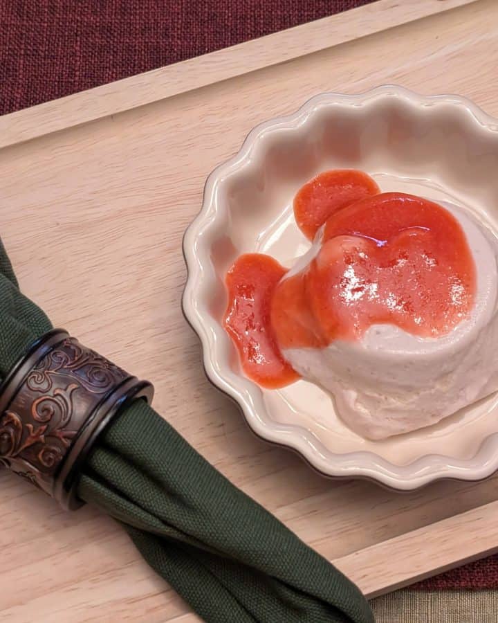 Strawberry Mango Sutra Panna Cotta in a serving dish topped with Strawberry Purée