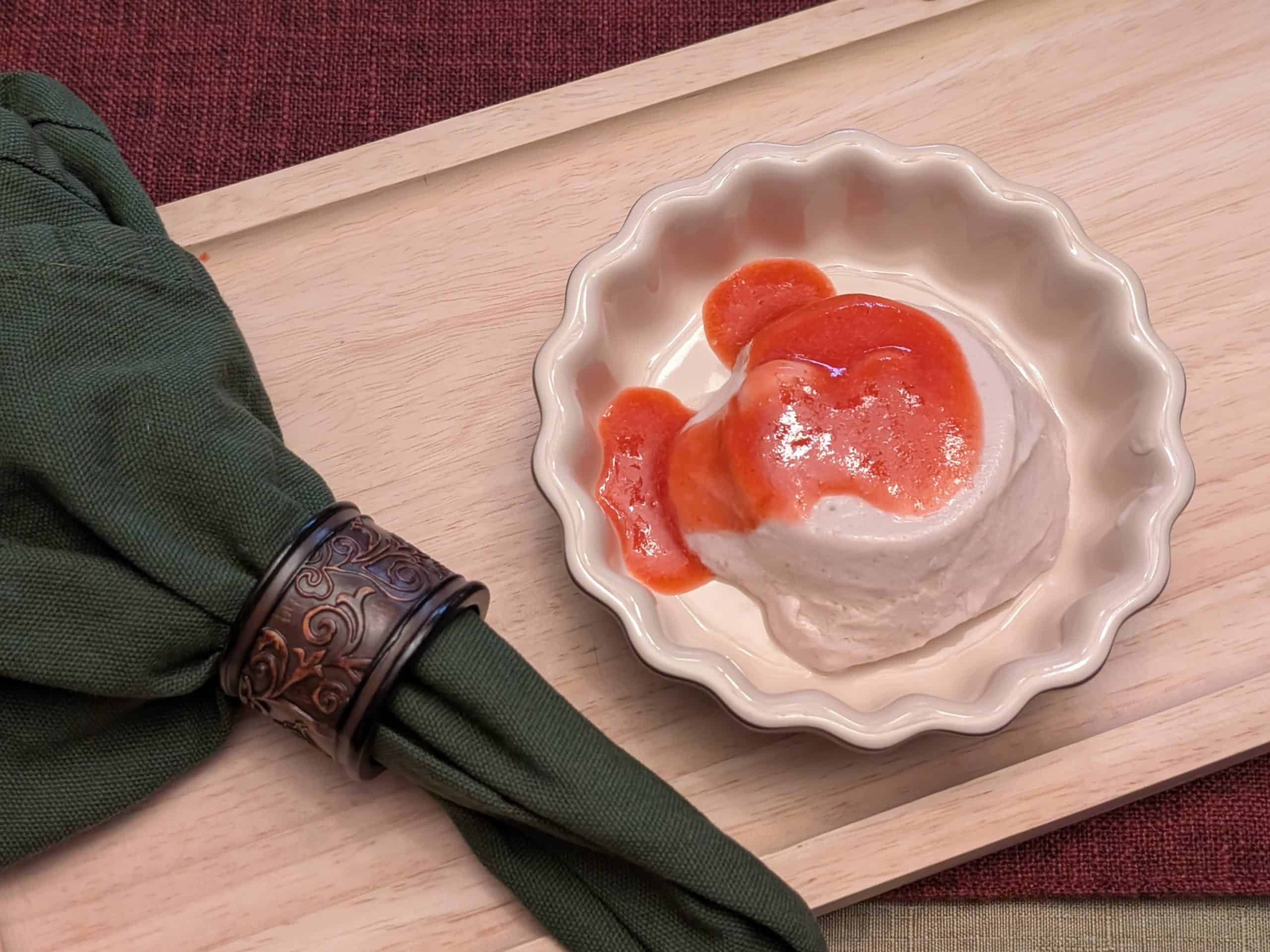 Strawberry Mango Sutra Panna Cotta in a serving dish topped with Strawberry Purée