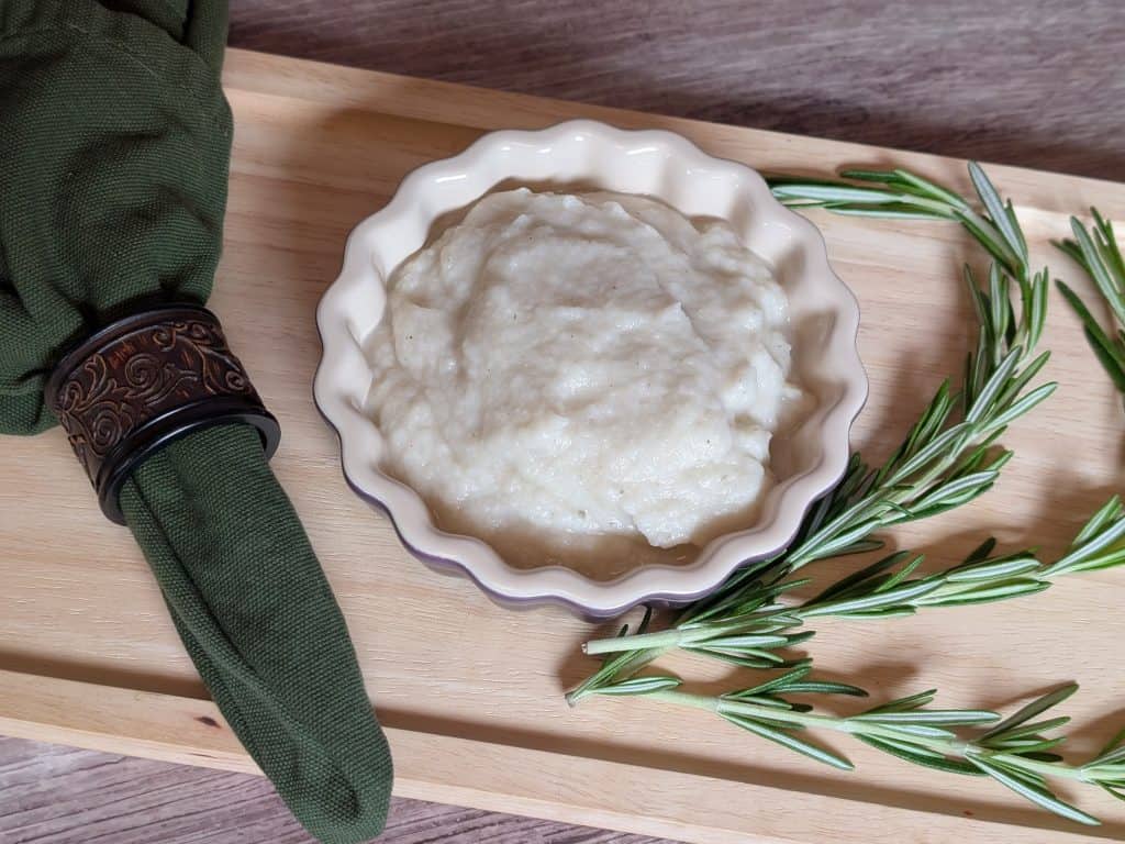 Turnip and Rosemary Purée plated next to sprigs of rosemary close-up