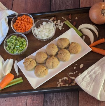 Classic Herb & Veggie Biscuits on a plate next to diced carrots, celery, and onion as well as large chunks of carrot, celery, and onion