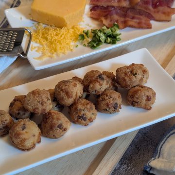 Bacon Cheddar Jalapeno Biscuit Bites - Plated with sliced of cooked bacon, diced jalapenos, and a block of shredded cheddar cheese - Close up